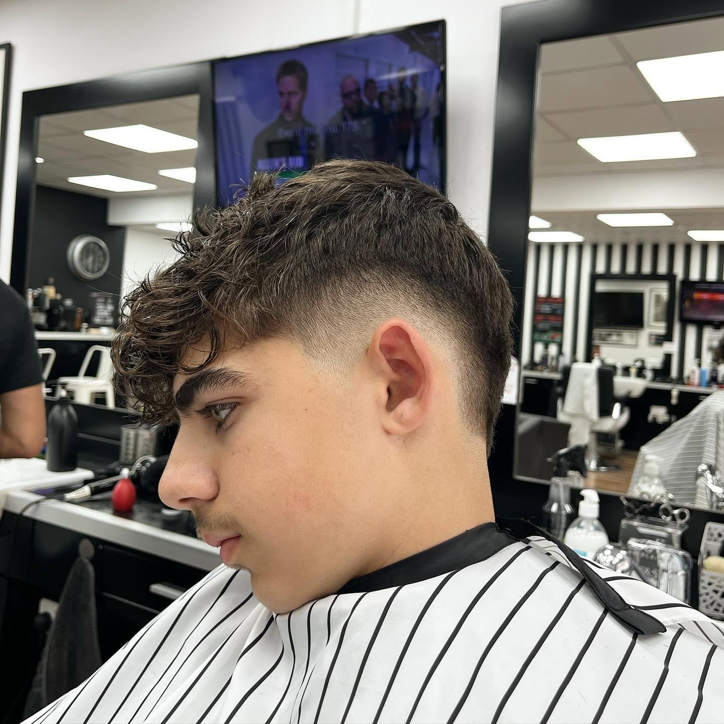 Curly crop with a clean fade at Andys Barbershop